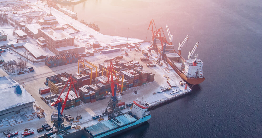 Container cargo ship loading North Arctic port. Concept freight transportation import export and business logistic, aerial view winter